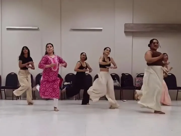 An open-level class working through a phrase in a mirrored studio