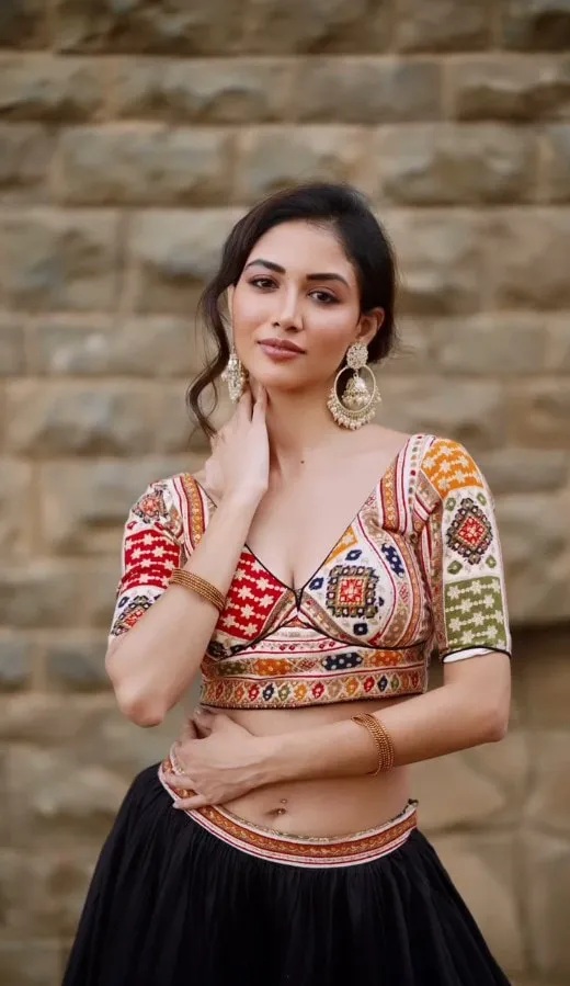 Divaksha in an embroidered mirrorwork choli against a stone wall