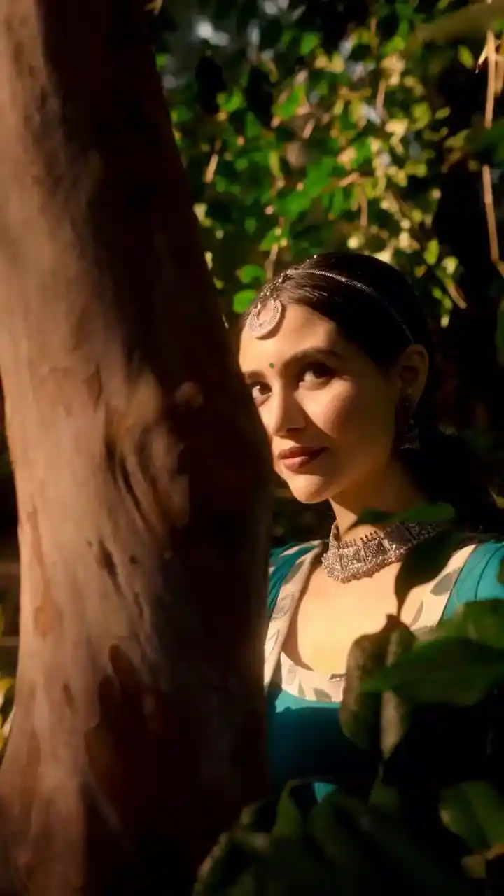 Divaksha Jinabhai in a teal anarkali beside a tree, looking towards the camera