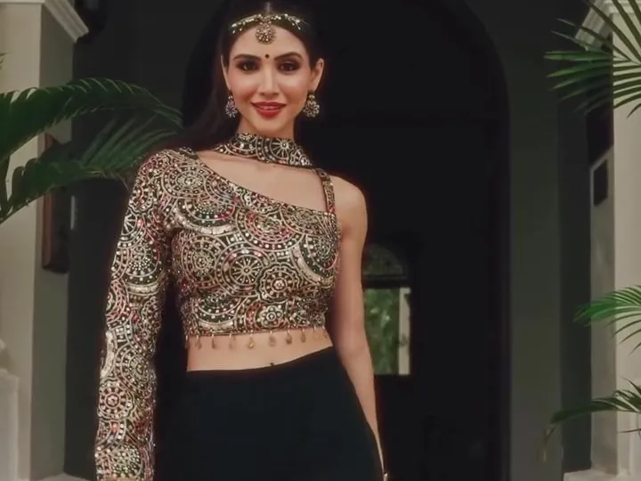 Divaksha in a gold embroidered top and black palazzo beneath a colonnade